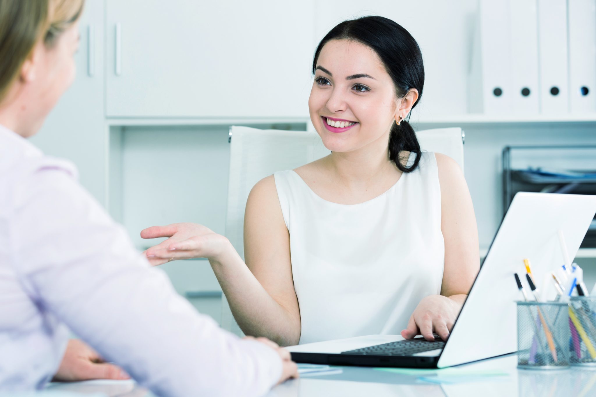 Doctor writing on medical health care record, patients discharge, or prescription form paperwork in hospital clinic office with physician’s stethoscope on desk